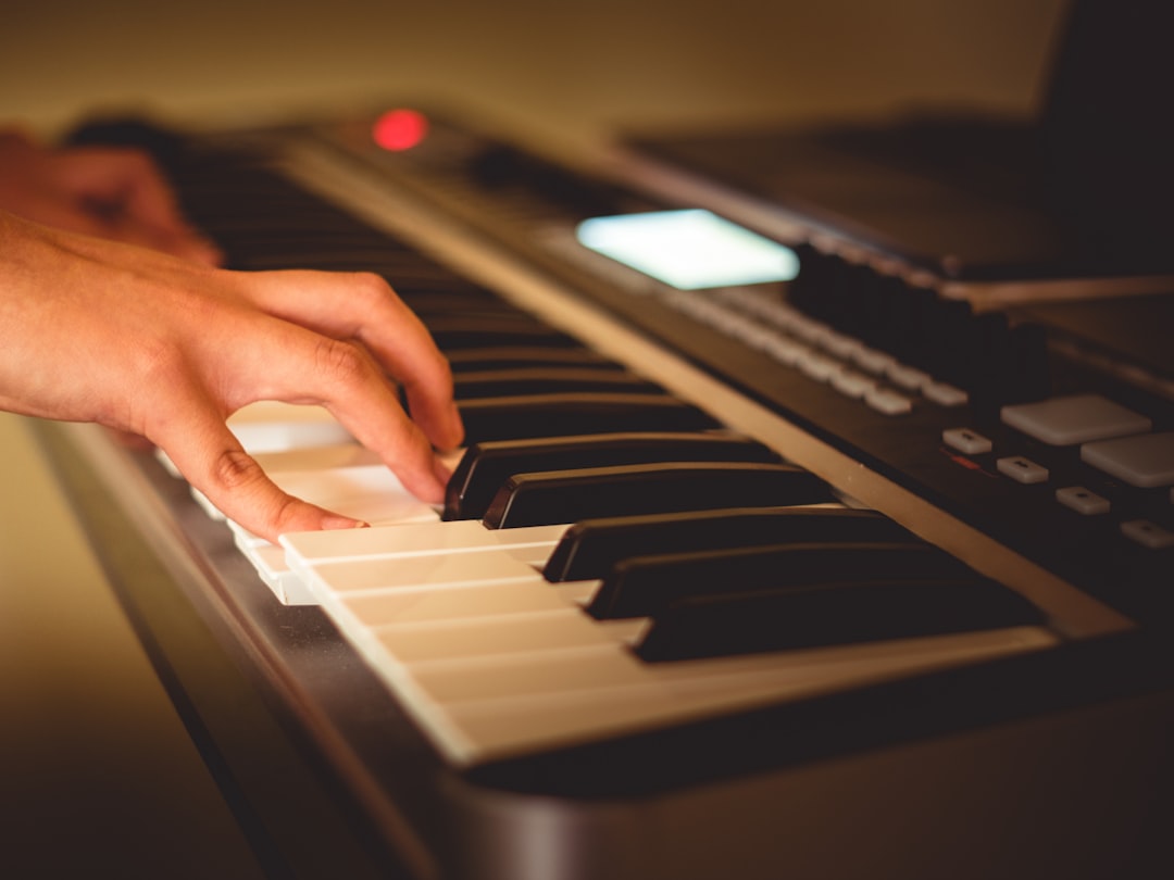 a person's hand on a piano keyboard