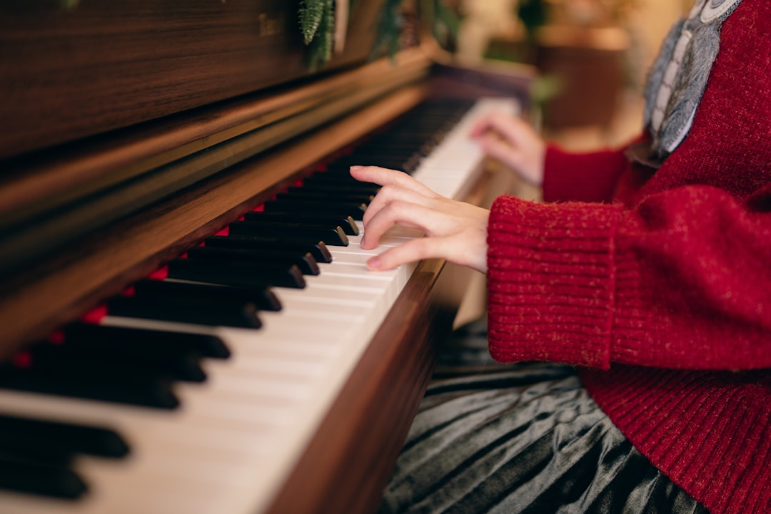 a woman in a red sweater is playing a piano