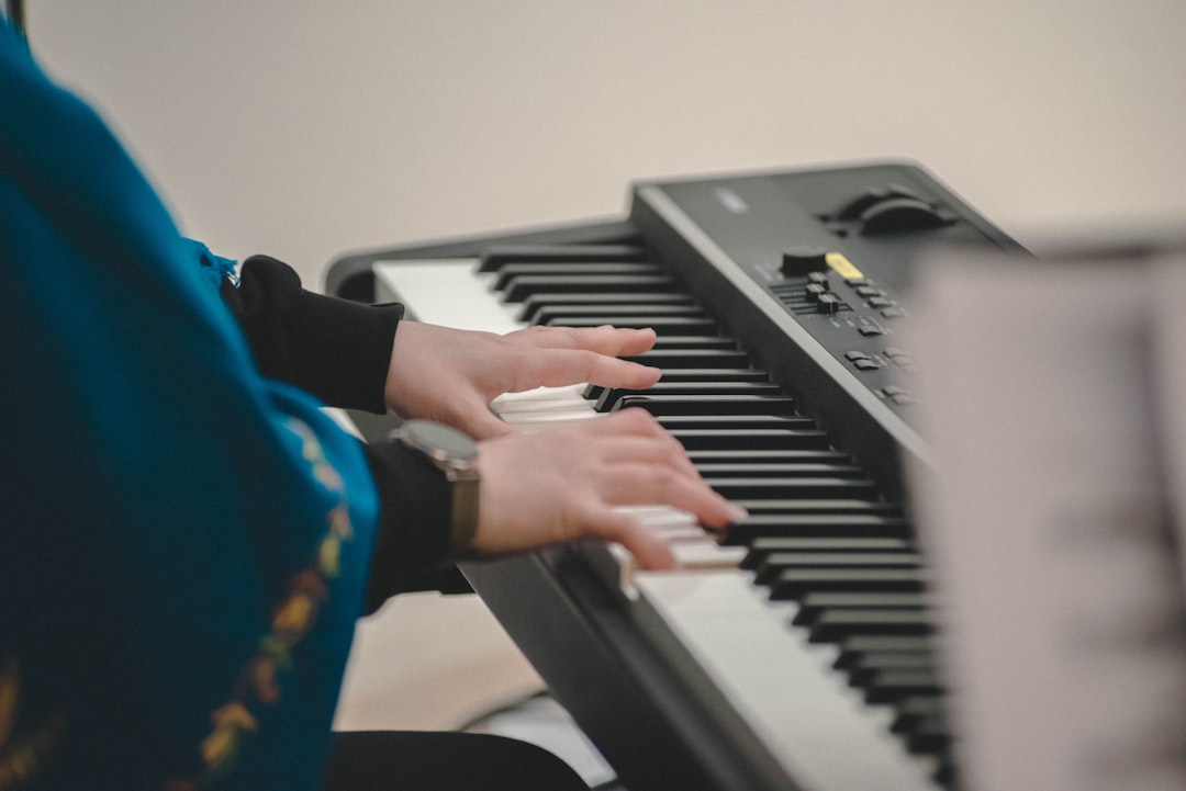 Person's hands playing a piano keyboard.
