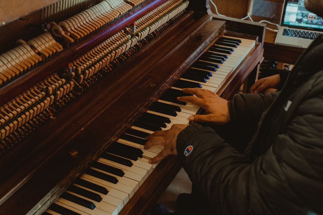 a person playing a brown upright piano