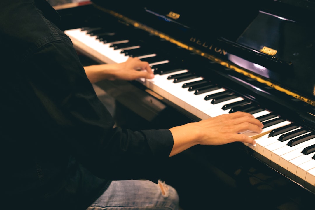 a person sitting at a piano playing a musical instrument