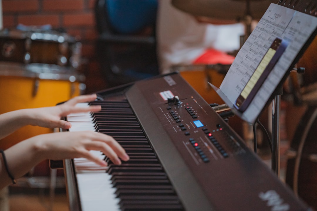 Hands playing a digital piano with sheet music